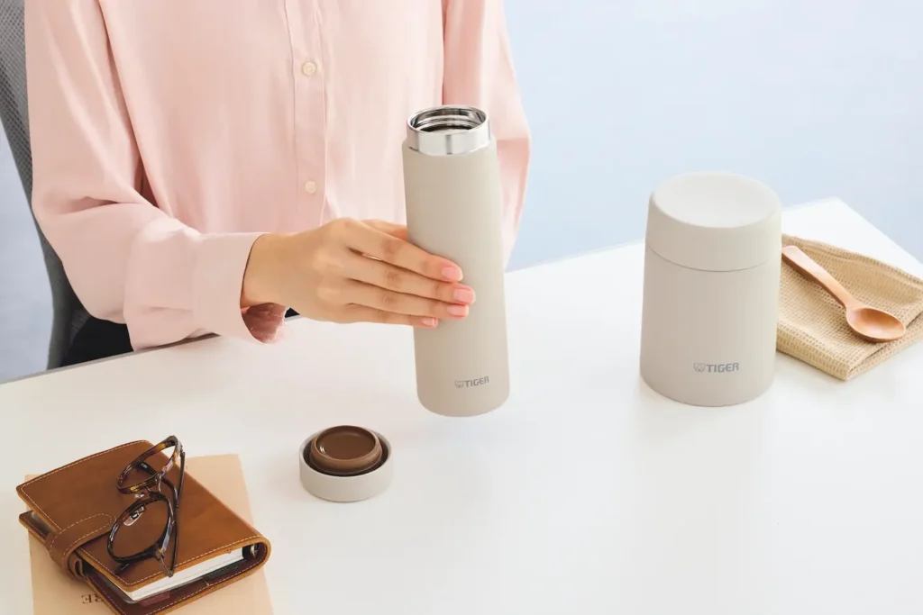 テーブルで水筒を持つ女性