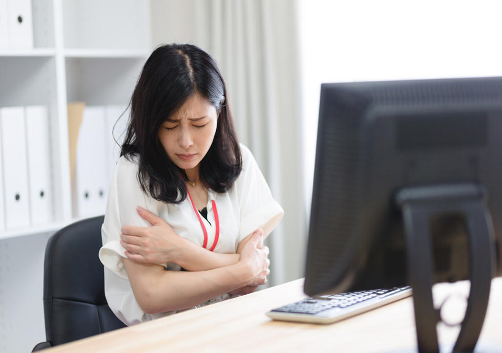 オフィスで凍える女性