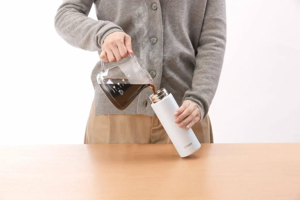 水筒にコーヒーを入れる女性