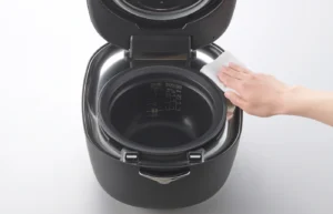 Someone cleaning a rice cooker.