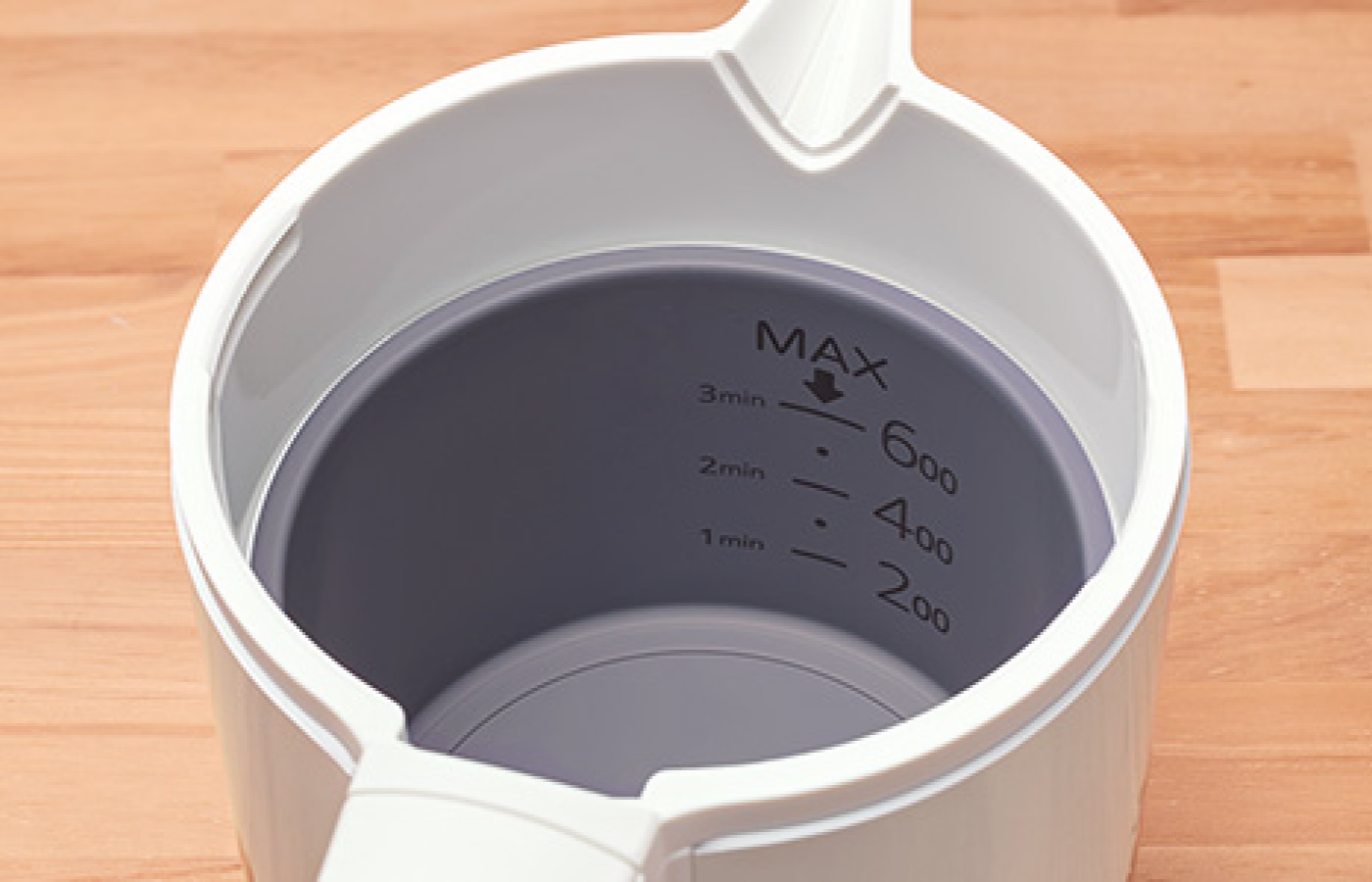 A view inside an electric kettle showing mineral buildup on the bottom.