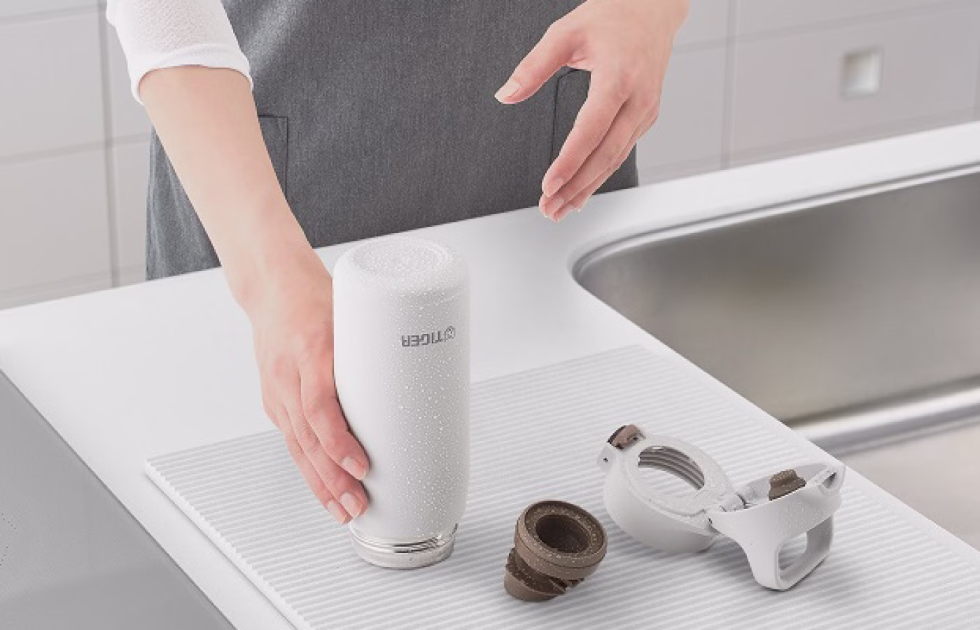A person carefully washing a water bottle with water.