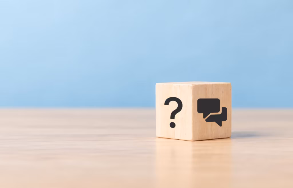 A wooden block featuring a question mark and a speech bubble icon.